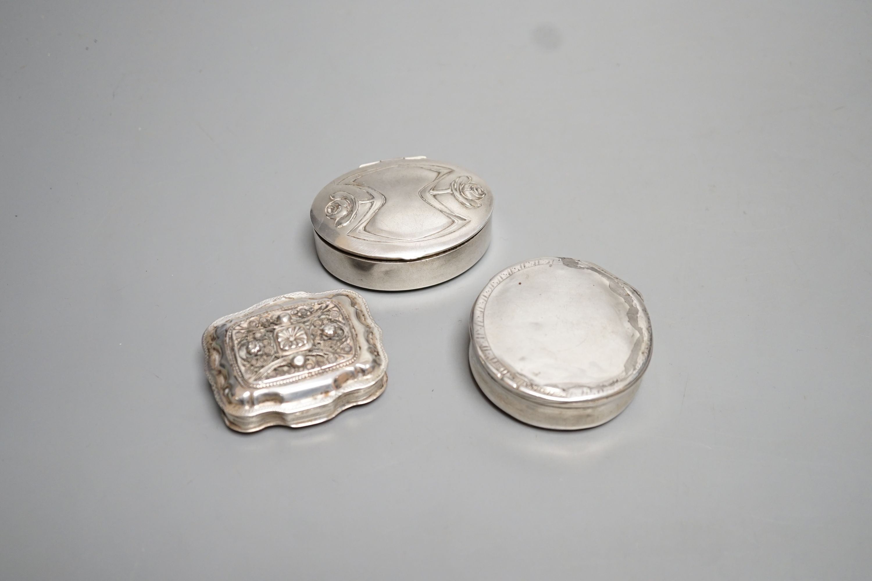 Three assorted continental white metal pill boxes including Dutch with filigree panel and German, largest 66mm.